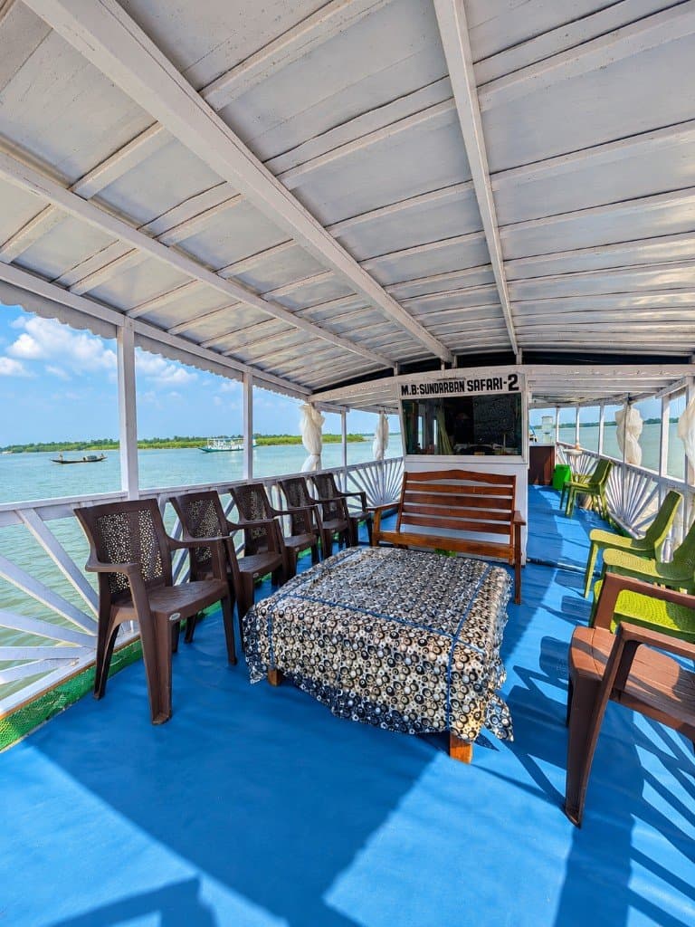 Upper deck of M.B. Sundarban Safari 2 at Mangrove Forest Camp with seating on the river